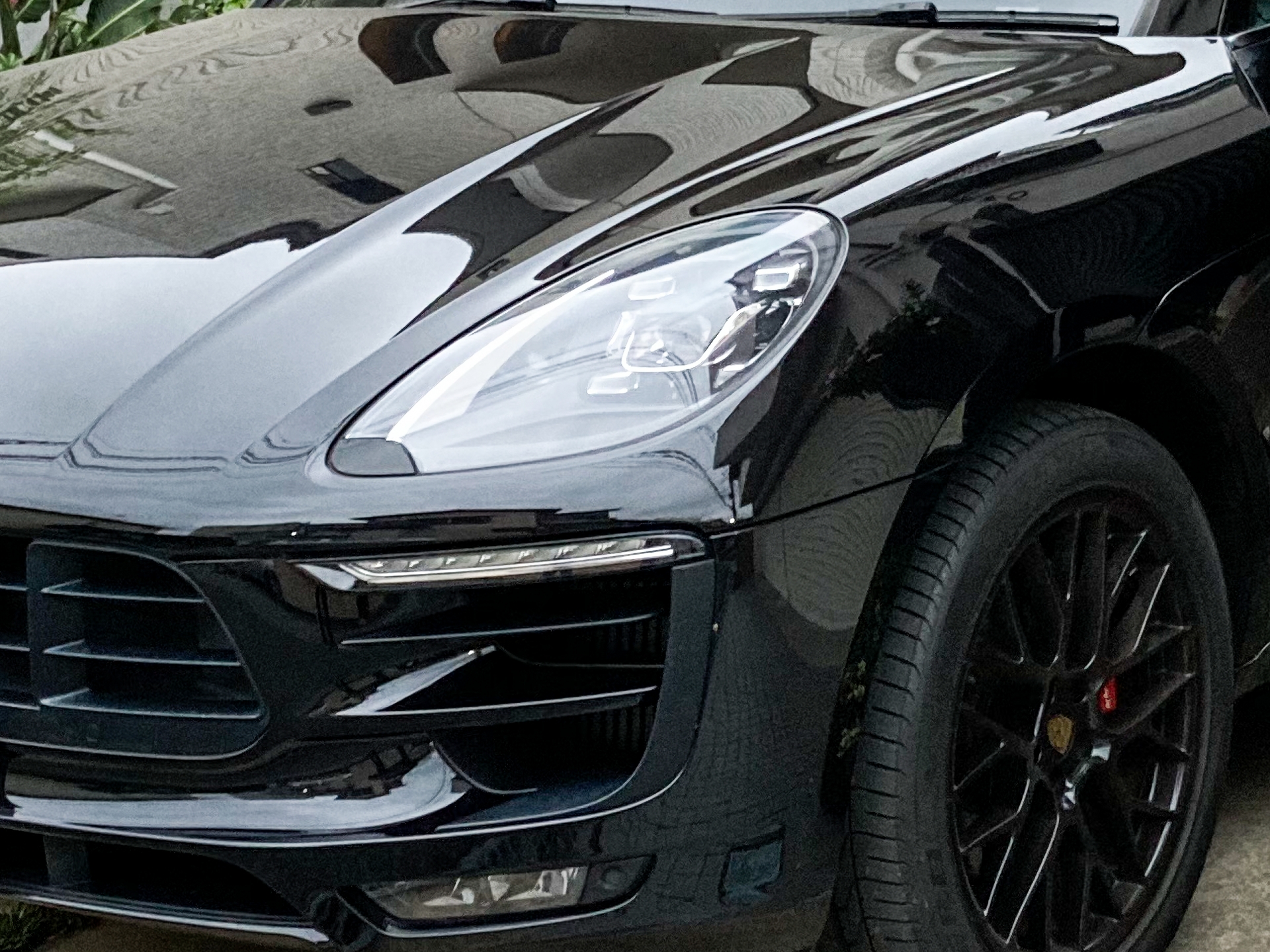 Black car body polished to a shiny mirror finish by buffing and compounding