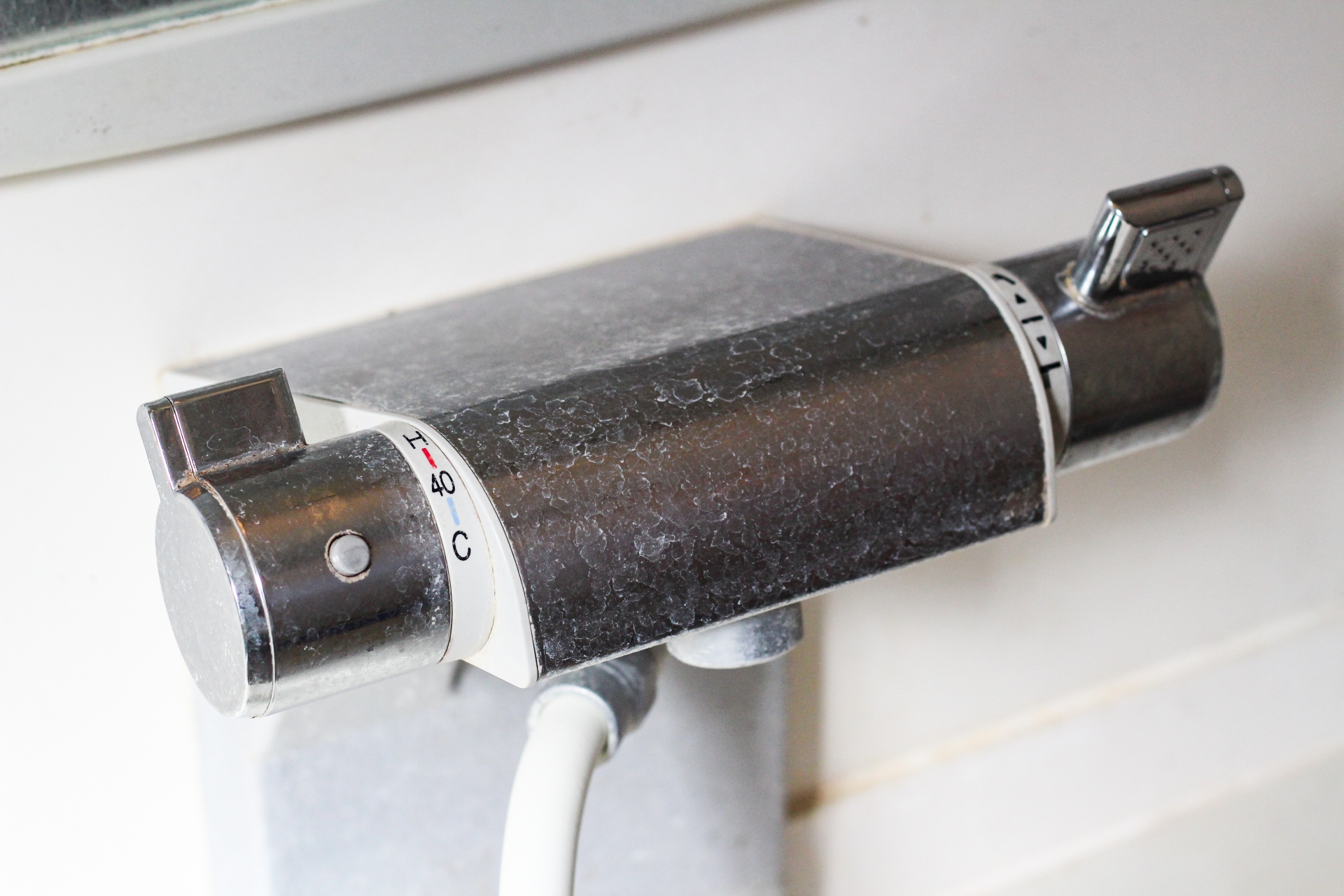 A washbasin faucet with water stains that are so stubborn they need to be polished with an abrasive.